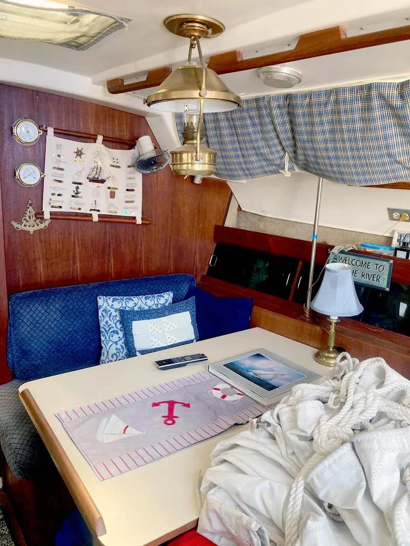 Slide: The Image of Cozy interior of 1983 Hunter 34 sailboat with nautical decor and dining area. - 11