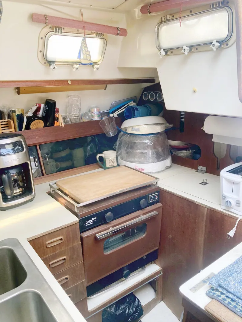 Slide: The Image of Compact kitchen in a 1983 Hunter 34 sailboat with appliances and storage. - 12