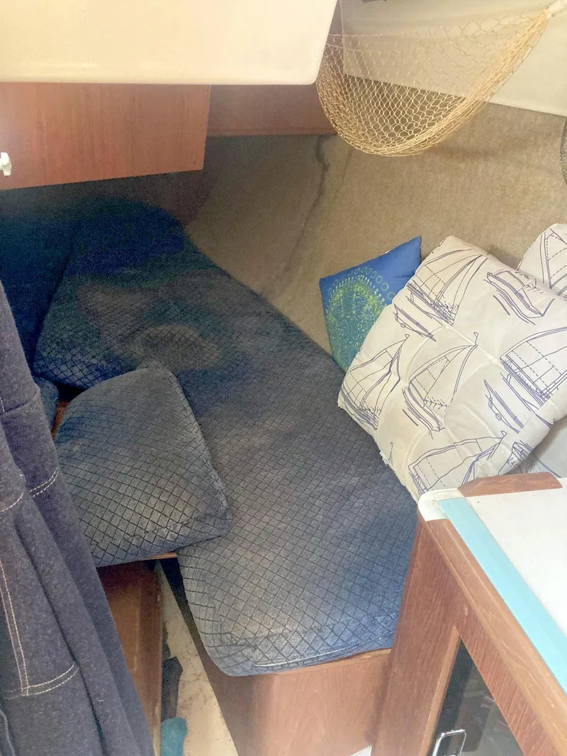 Slide: The Image of Cozy cabin interior of 1983 Hunter 34 sailboat with nautical-themed cushions. - 14