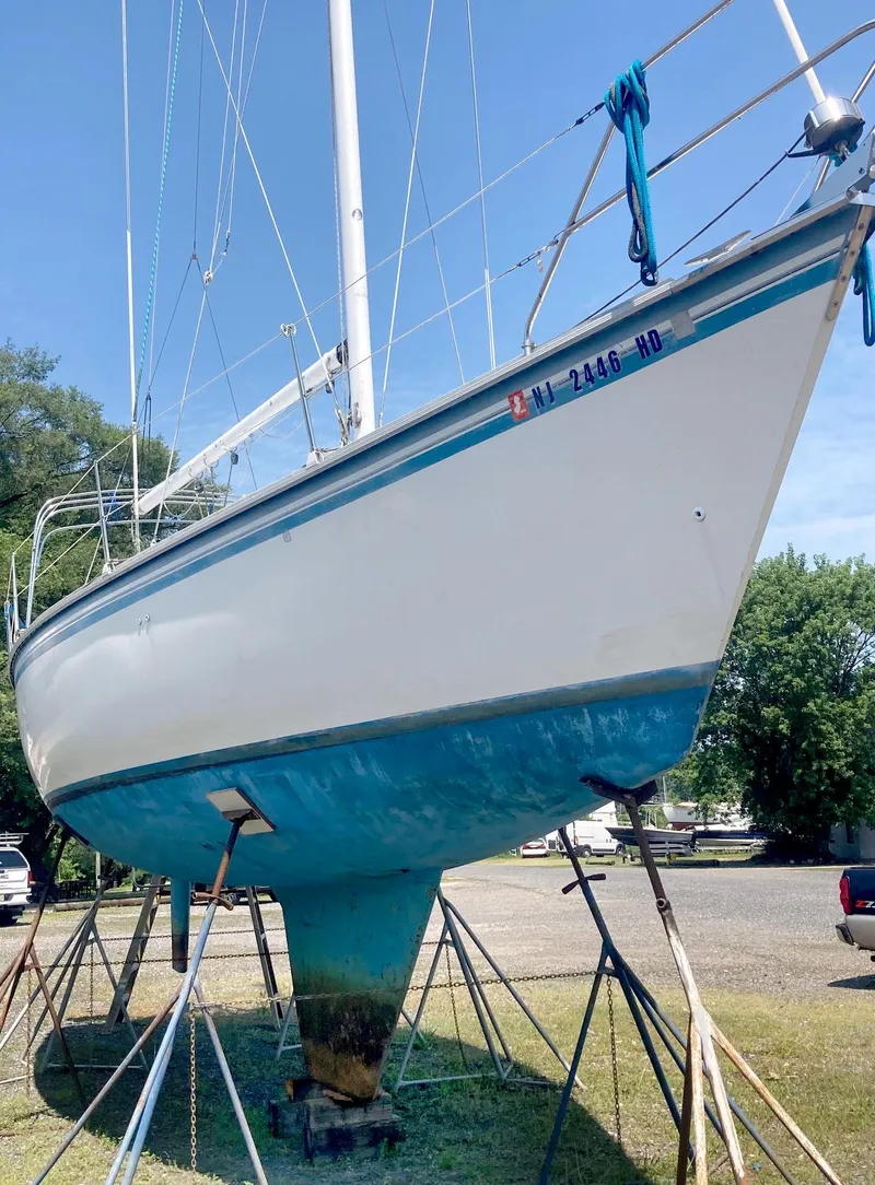 Slide: The Image of 1983 Hunter 34 sailboat on stands, blue hull, outdoors, sunny day. - 2