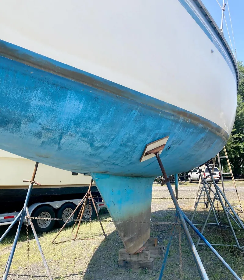 Slide: The Image of 1983 Hunter 34 sailboat hull on stands, blue and white exterior. - 5