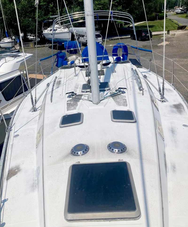 Slide: The Image of 1983 Hunter 34 sailboat deck with hatches and rigging, docked in a marina. - 9