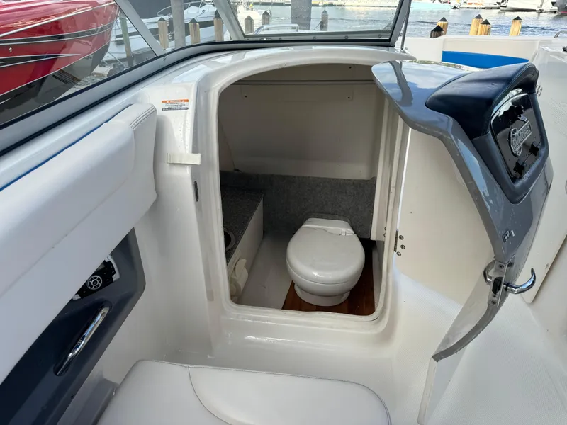 Slide: The Image of 2017 Chaparral 250 Suncoast boat interior with compact marine toilet. - 16