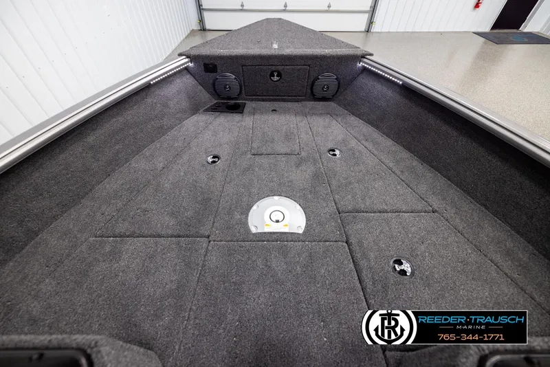 Slide: The Image of 2025 Lund 1875 Impact XS boat interior with carpeted deck and storage compartments. - 14