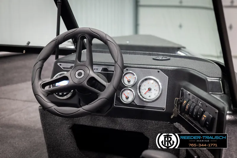 Slide: The Image of 2025 Lund 1875 Impact XS boat dashboard with steering wheel and gauges. - 23