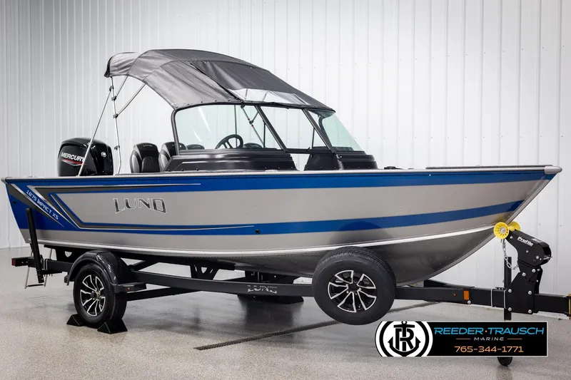 Slide: The Image of 2025 Lund 1875 Impact XS boat with blue and silver design on a trailer. - 3