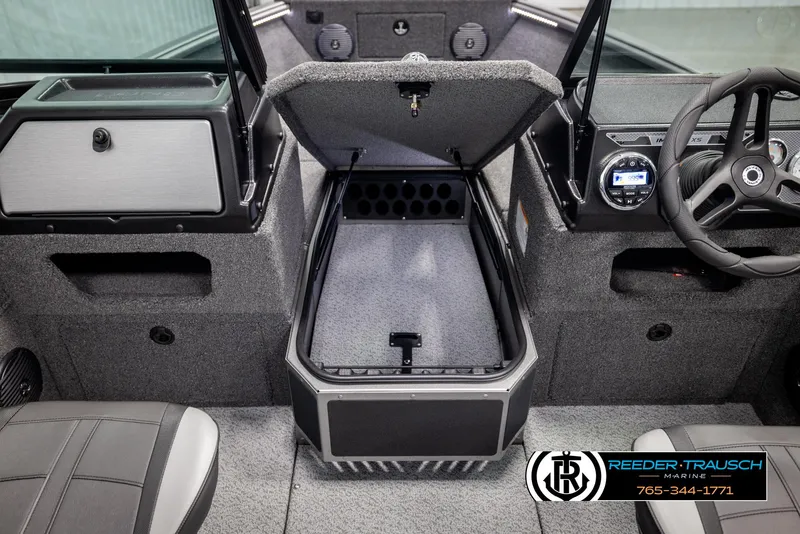 Slide: The Image of 2025 Lund 1875 Impact XS boat interior with open storage compartment and steering wheel. - 33