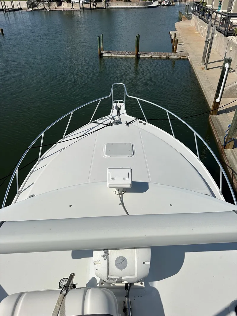 Slide: The Image of 2000 Cabo 31 Express boat docked in a marina, viewed from the bow. - 12