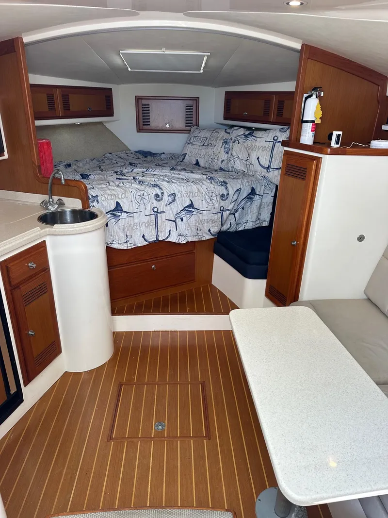 Slide: The Image of Interior of 2000 Cabo 31 Express boat with cozy cabin and nautical decor. - 13