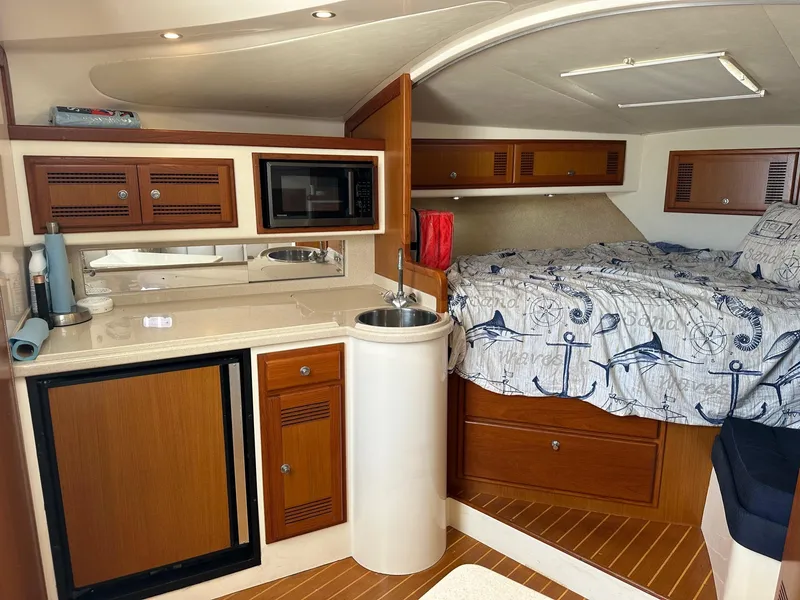 Slide: The Image of Interior of 2000 Cabo 31 Express boat with kitchenette and cozy sleeping area. - 15