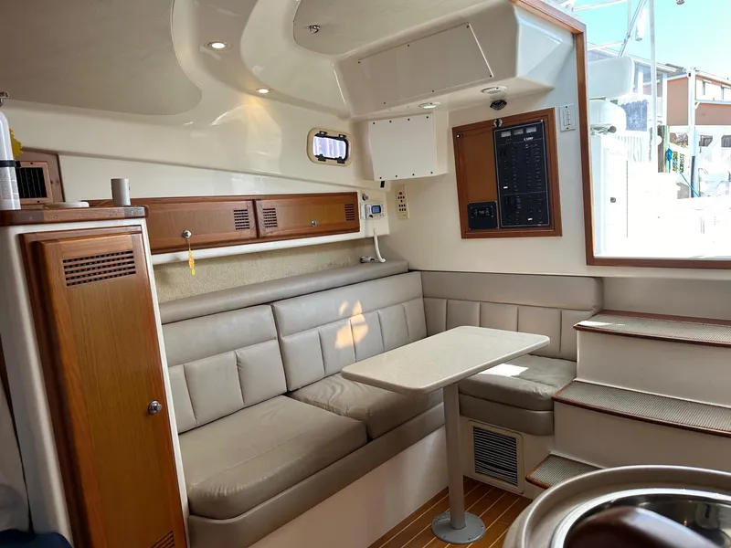 Slide: The Image of Interior of 2000 Cabo 31 Express boat with beige seating and wooden accents. - 16
