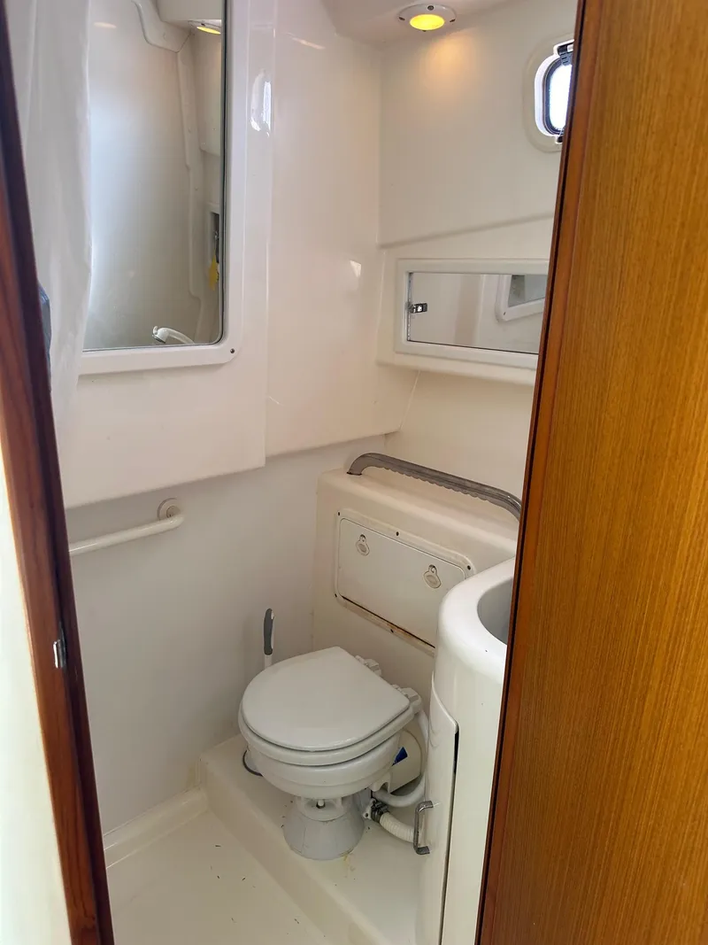 Slide: The Image of 2000 Cabo 31 Express boat bathroom with toilet, sink, and mirror. - 18