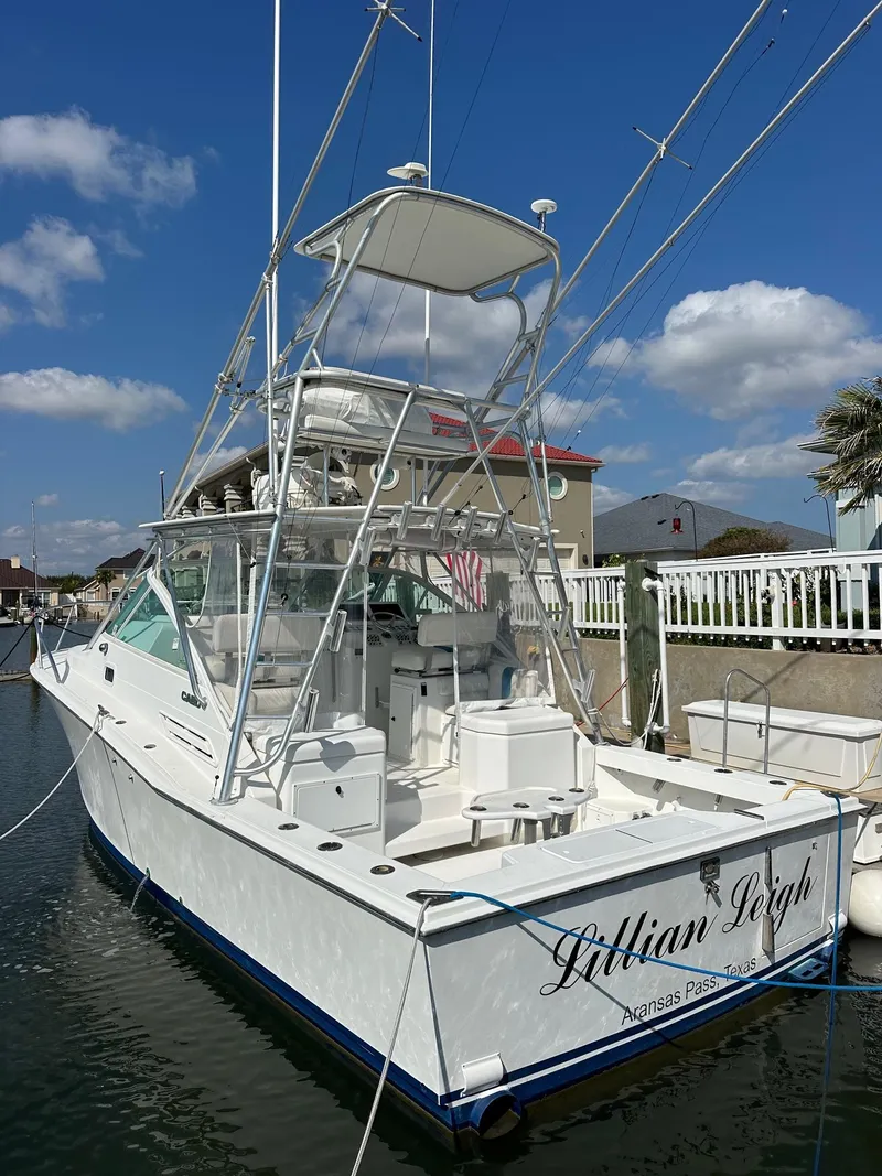 Slide: The Image of 2000 Cabo 31 Express boat docked under clear blue sky. - 2