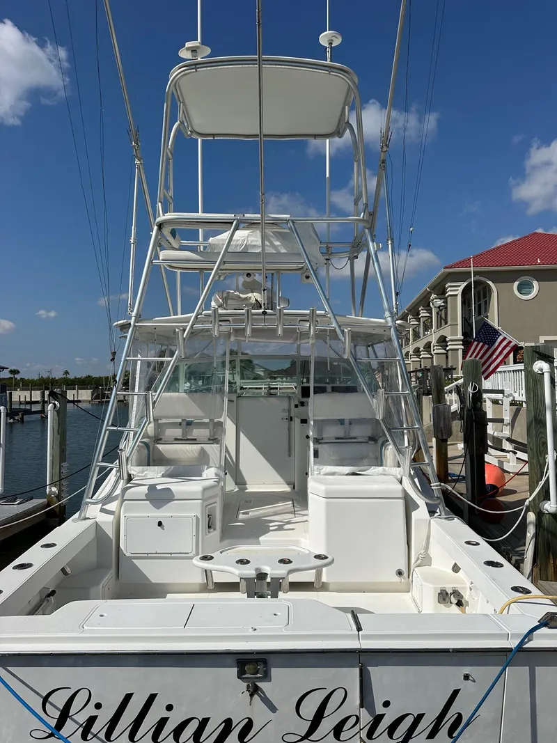 Slide: The Image of 2000 Cabo 31 Express boat docked, featuring a spacious deck and tower under a clear blue sky. - 3
