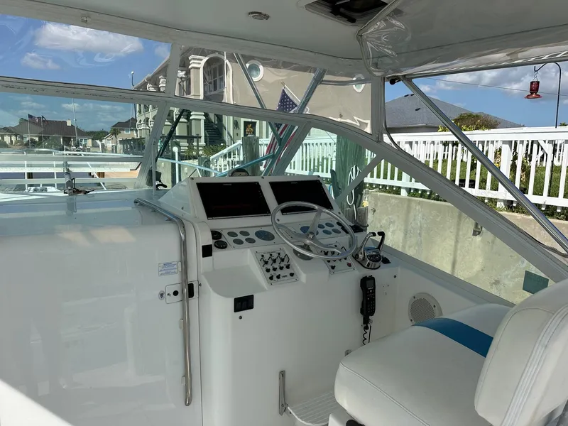 Slide: The Image of 2000 Cabo 31 Express boat cockpit with steering wheel and control panel. - 5
