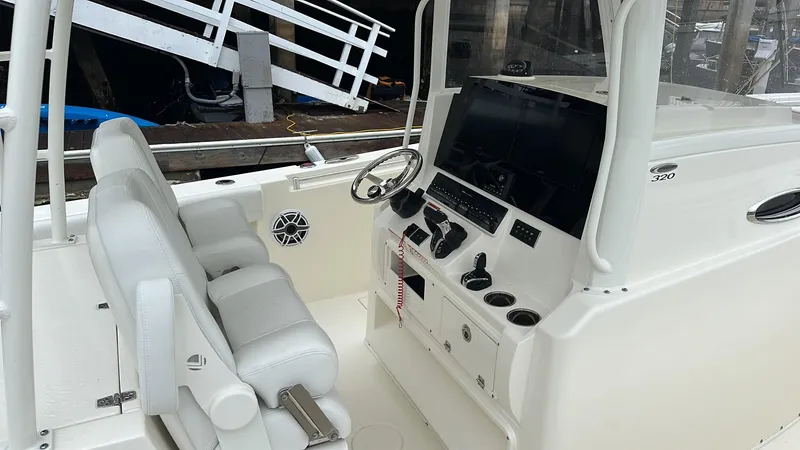 Slide: The Image of 2024 Cobia 320 Center Console boat interior with helm and seating. - 2