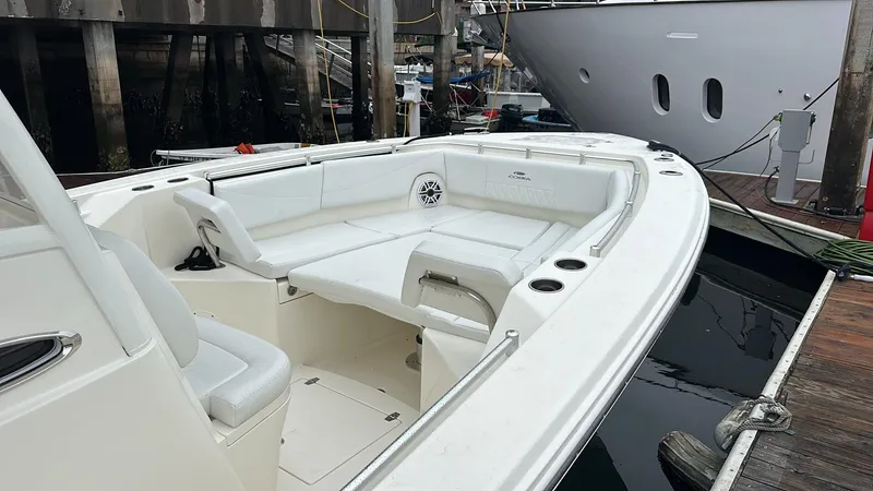 Slide: The Image of 2024 Cobia 320 Center Console boat with spacious seating at a dock. - 5