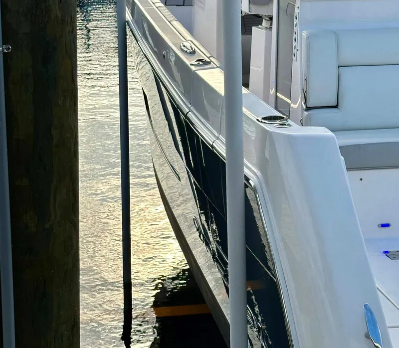 Slide: The Image of 2021 Regal 38 SAV yacht docked, reflecting sunlight on water. - 10