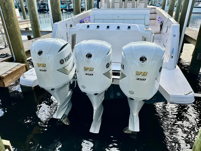 Slide: The Image of 2021 Regal 38 SAV boat with triple Yamaha V8 350 engines at dock. - 12