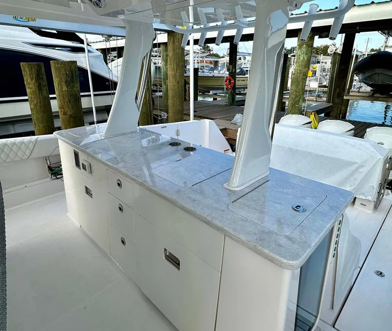 Slide: The Image of 2021 Regal 38 SAV yacht with sleek outdoor kitchen and marina backdrop. - 24