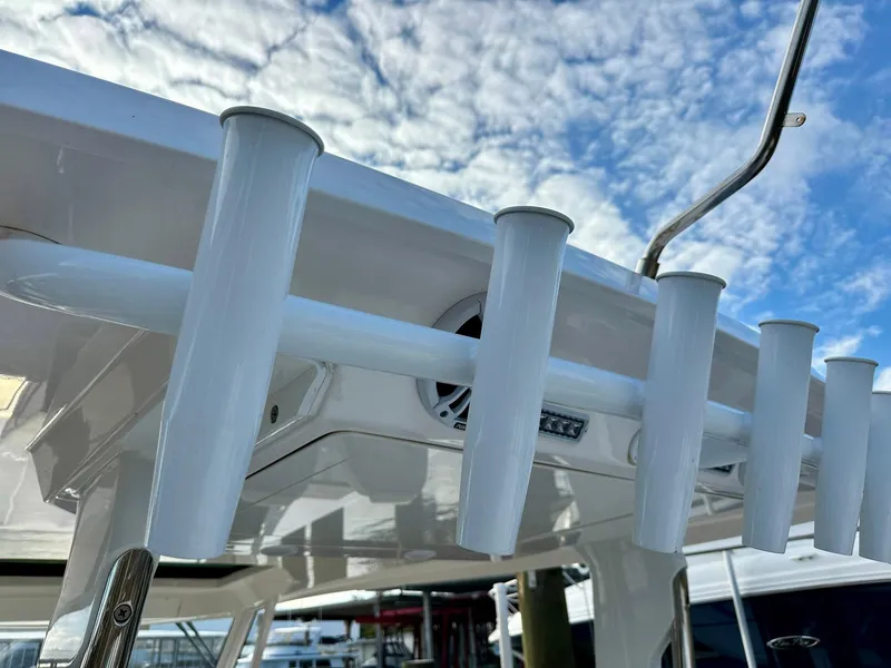 Slide: The Image of 2021 Regal 38 SAV boat rod holders under a blue sky. - 29