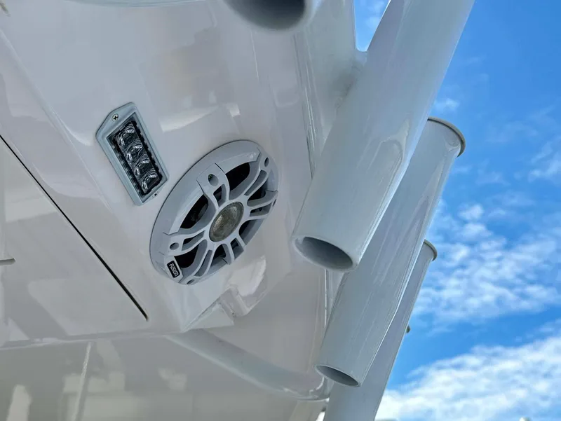 Slide: The Image of Close-up of 2021 Regal 38 SAV boat speaker and rod holders against blue sky. - 30