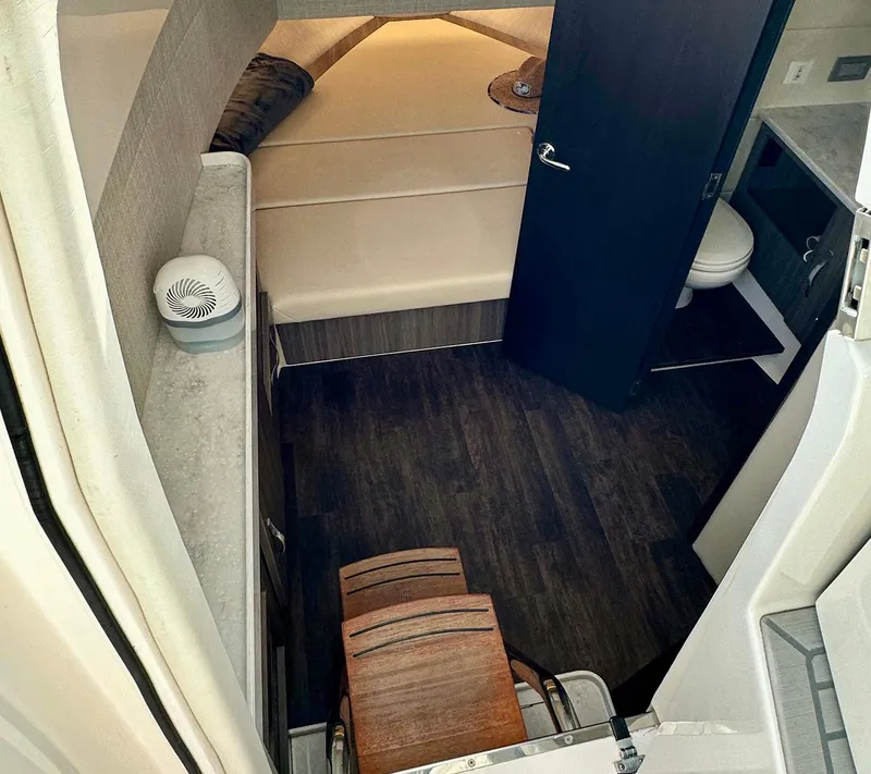 Slide: The Image of 2021 Regal 38 SAV cabin interior with bed, dark wood flooring, and compact bathroom. - 34