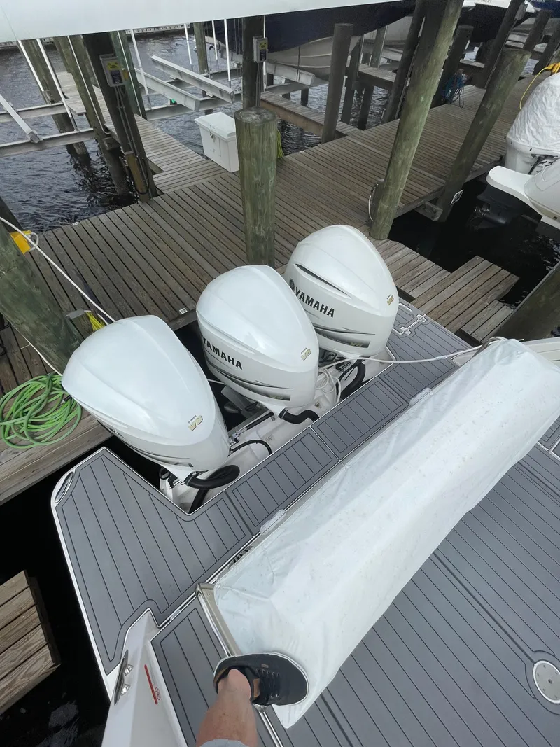 Slide: The Image of 2021 Regal 38 SAV boat with triple Yamaha outboard engines at dock. - 44