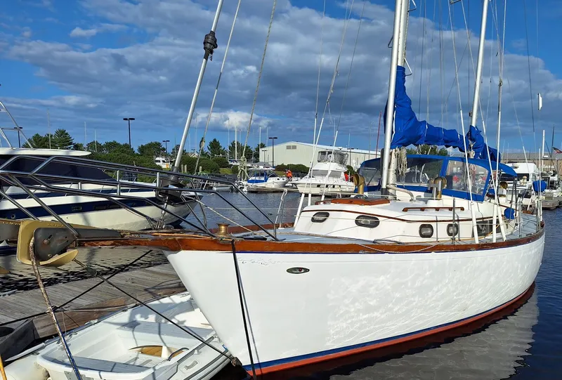 The Image of 1976 Cheoy Lee 40 Center Cockpit sailboat docked at marina under blue sky. - 0