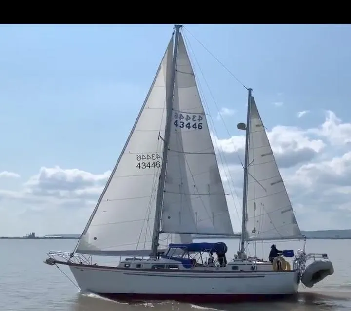 Slide: The Image of 1976 Cheoy Lee 40 Center Cockpit sailboat cruising on calm waters under clear skies. - 1