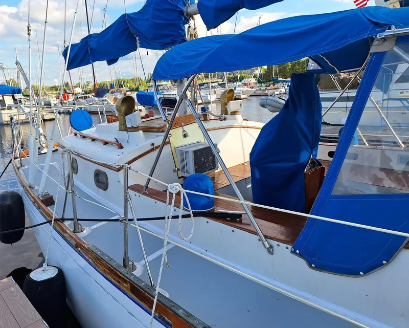 Slide: The Image of 1976 Cheoy Lee 40 Center Cockpit sailboat with blue covers docked at marina. - 10