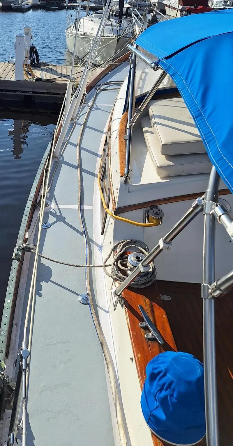 Slide: The Image of 1976 Cheoy Lee 40 Center Cockpit sailboat with blue canopy, docked at marina. - 11