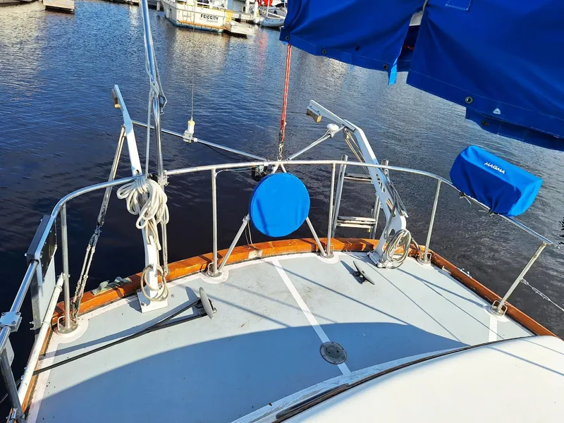 Slide: The Image of 1976 Cheoy Lee 40 Center Cockpit sailboat docked, featuring blue covers and nautical equipment. - 14