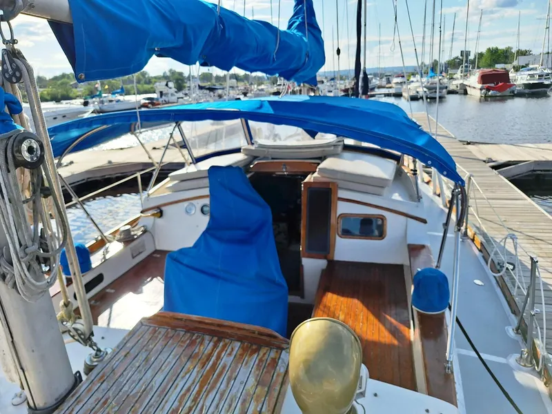 Slide: The Image of 1976 Cheoy Lee 40 Center Cockpit sailboat docked at marina with blue covers. - 15