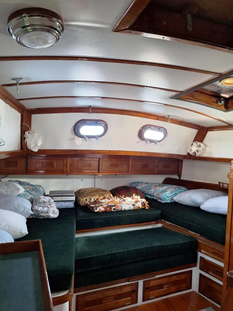 Slide: The Image of 1976 Cheoy Lee 40 Center Cockpit interior with cozy seating and wooden accents. - 24