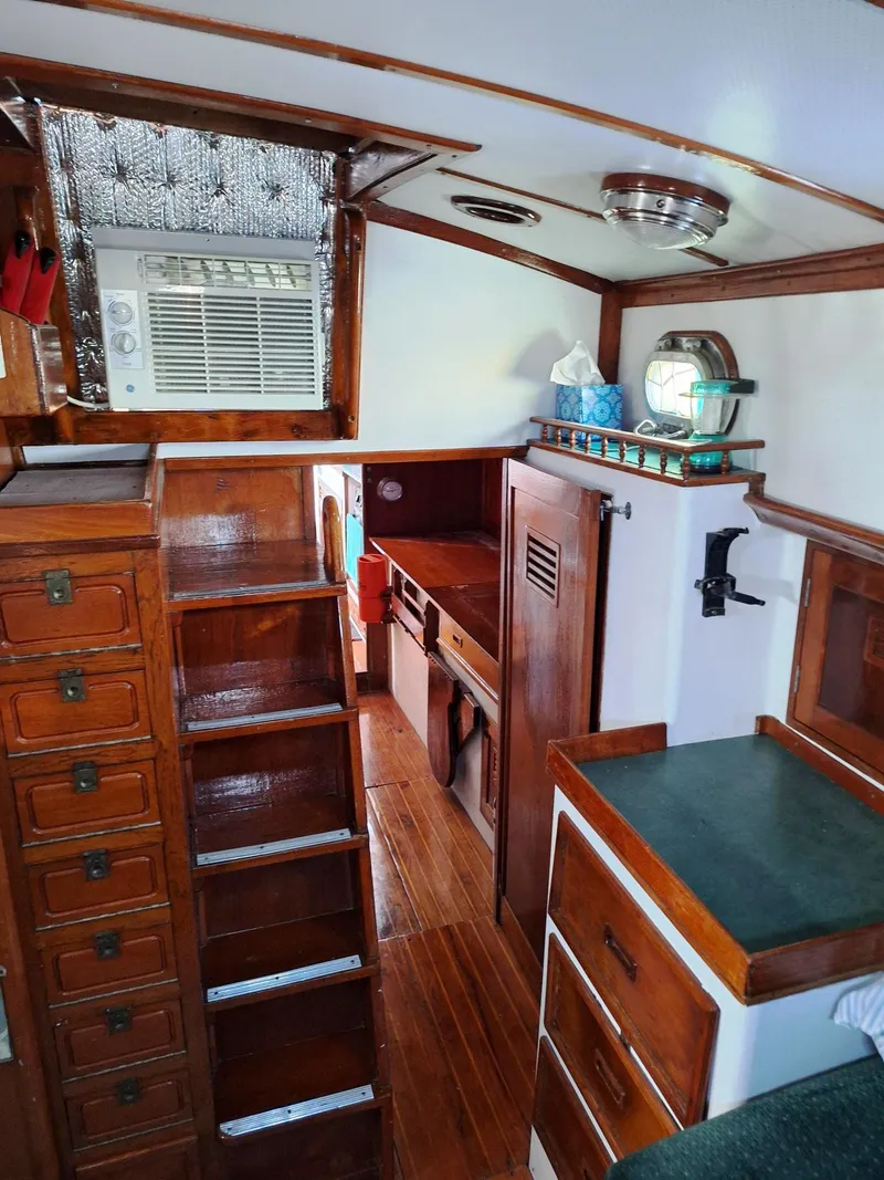 Slide: The Image of 1976 Cheoy Lee 40 Center Cockpit interior with wood finish and compact kitchen area. - 25