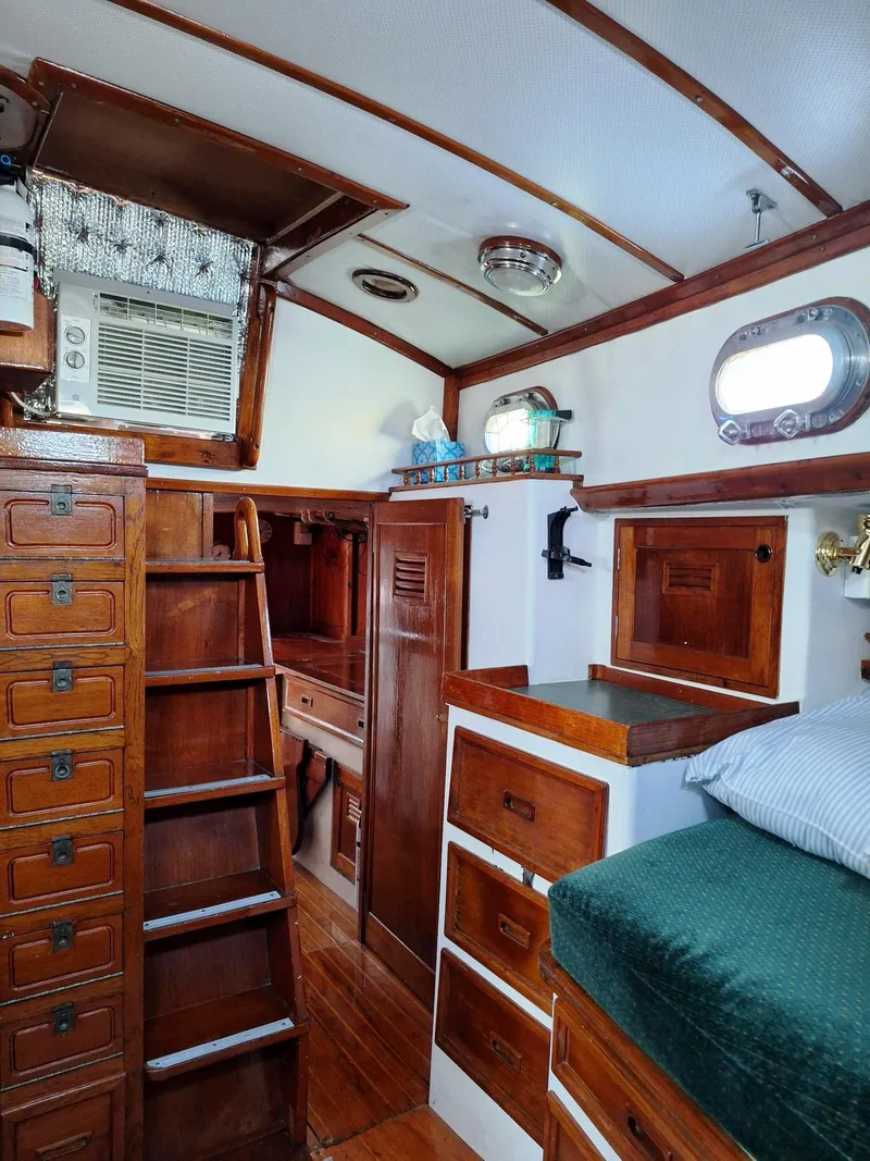 Slide: The Image of 1976 Cheoy Lee 40 Center Cockpit interior with wooden cabinetry and cozy sleeping area. - 26