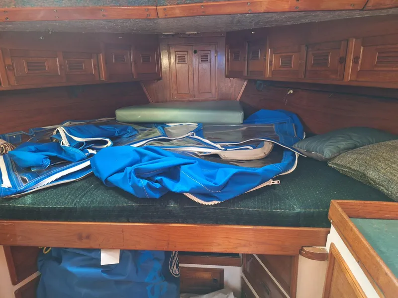 Slide: The Image of 1976 Cheoy Lee 40 Center Cockpit interior with blue sails and wooden cabinetry. - 28