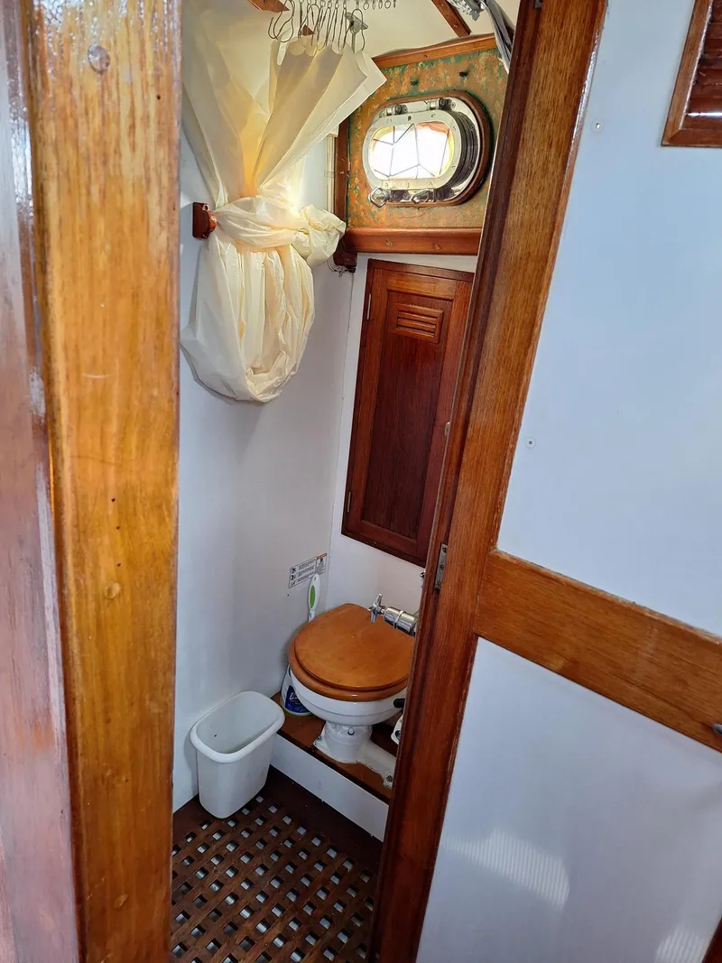 Slide: The Image of 1976 Cheoy Lee 40 Center Cockpit bathroom with wooden accents and nautical decor. - 29