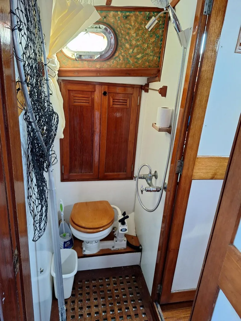 Slide: The Image of 1976 Cheoy Lee 40 Center Cockpit bathroom with wooden accents and nautical decor. - 31