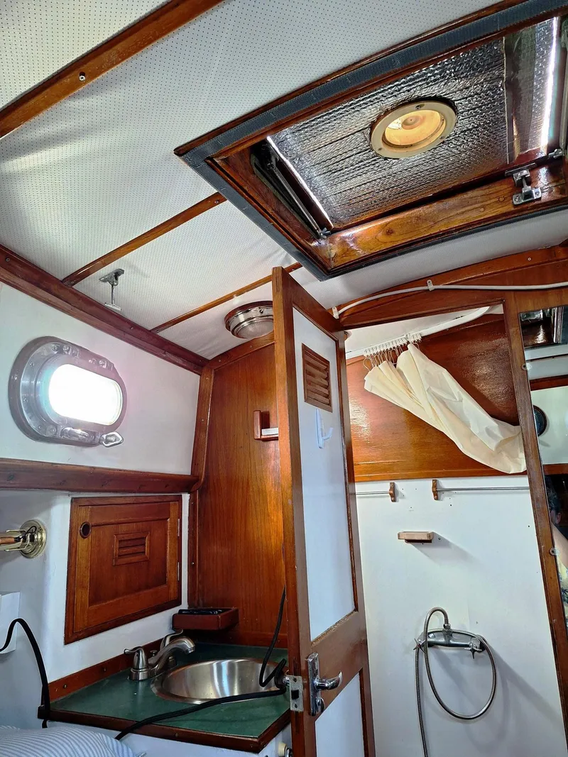 Slide: The Image of 1976 Cheoy Lee 40 Center Cockpit interior with wood accents and porthole window. - 32
