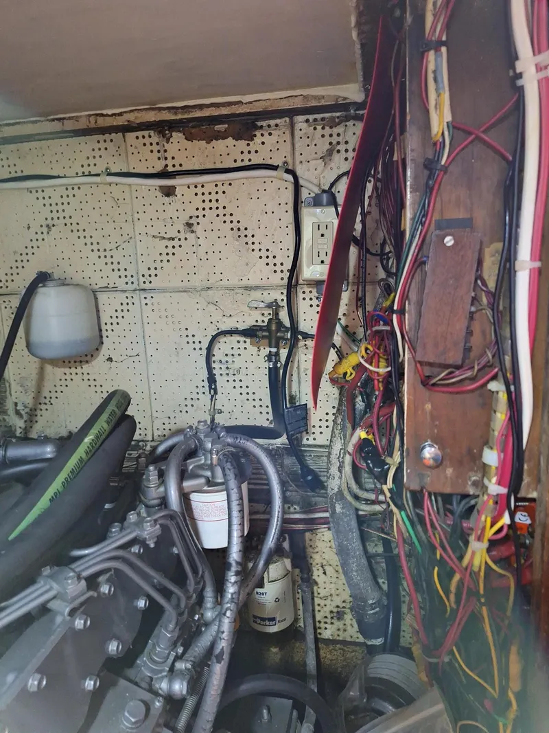 Slide: The Image of Engine room of a 1976 Cheoy Lee 40 Center Cockpit sailboat with visible wiring and components. - 38