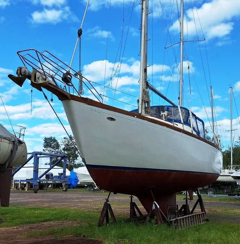 Slide: The Image of 1976 Cheoy Lee 40 Center Cockpit sailboat on stands, under a blue sky. - 4