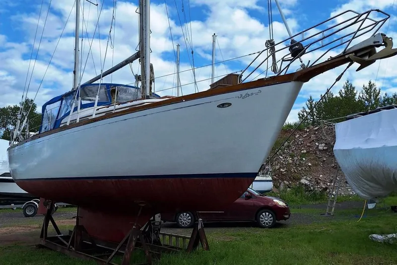 Slide: The Image of 1976 Cheoy Lee 40 Center Cockpit sailboat on land, blue sky background. - 5