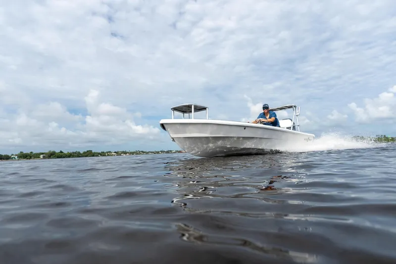 Slide: The Image of 2025 BlueZones Boatworks 16' Flats cruising on open water under a cloudy sky. - 10