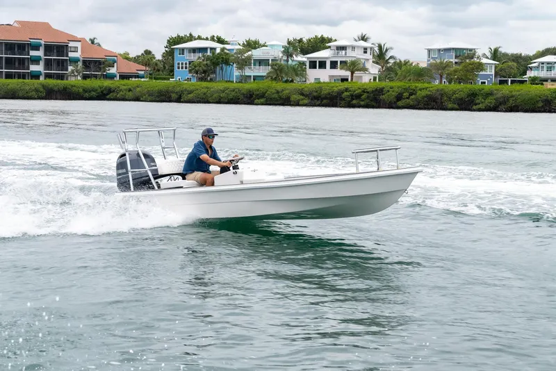 Slide: The Image of 2025 BlueZones Boatworks 16' Flats cruising on water near waterfront homes. - 30