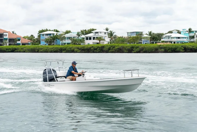 Slide: The Image of 2025 BlueZones Boatworks 16' Flats cruising on a scenic waterway. - 31