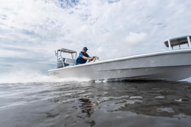 Slide: The Image of 2025 BlueZones Boatworks 16' Flats boat speeding on water under cloudy sky. - 9