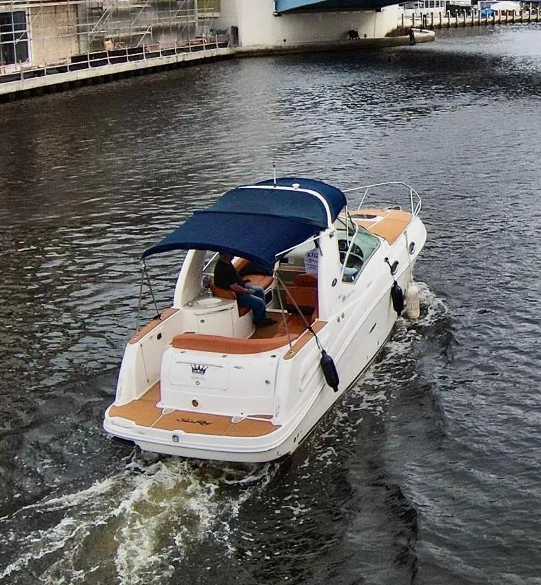 Slide: The Image of 2005 Sea Ray 260 Sundancer cruising on a canal with blue canopy. - 1