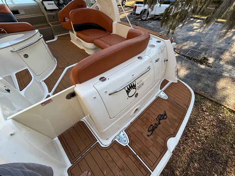 Slide: The Image of 2005 Sea Ray 260 Sundancer boat interior with brown seating and wood flooring. - 12